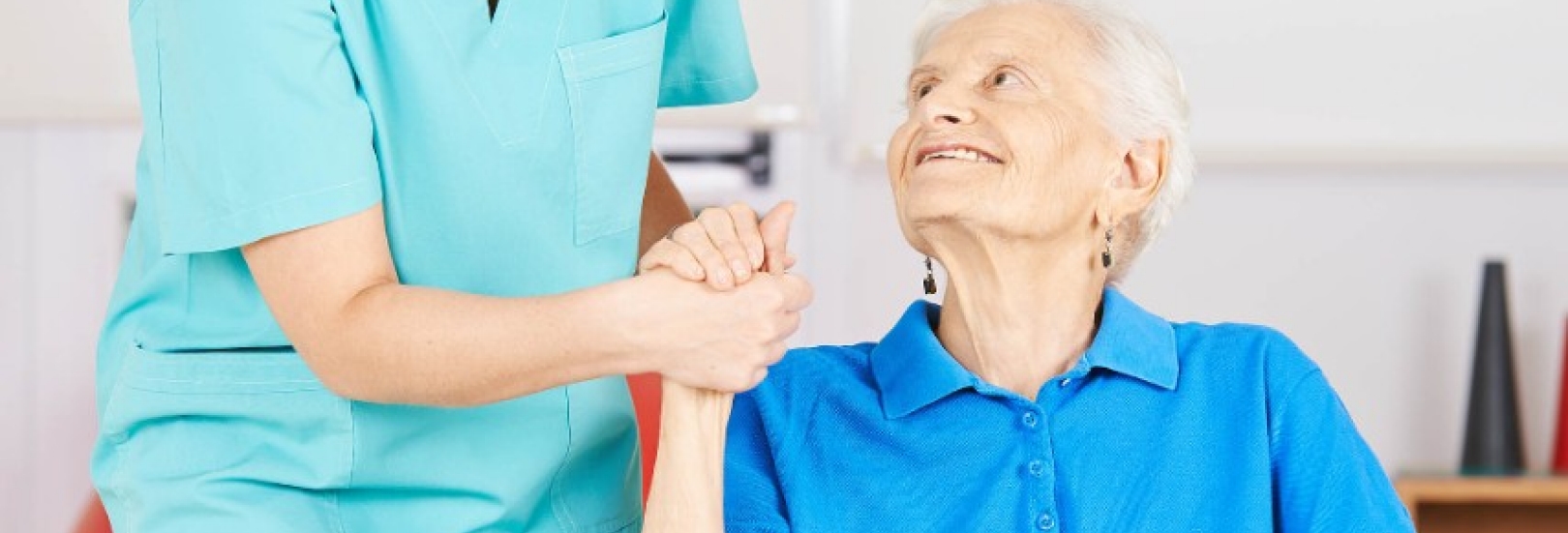 Krankenpflegerin hält Hand einer alten Frau