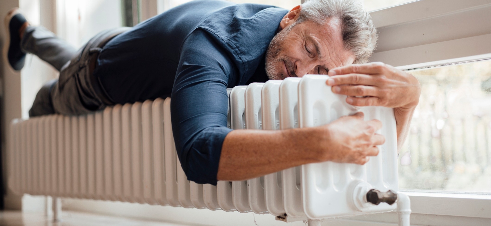 Mann liegt auf der Heizung