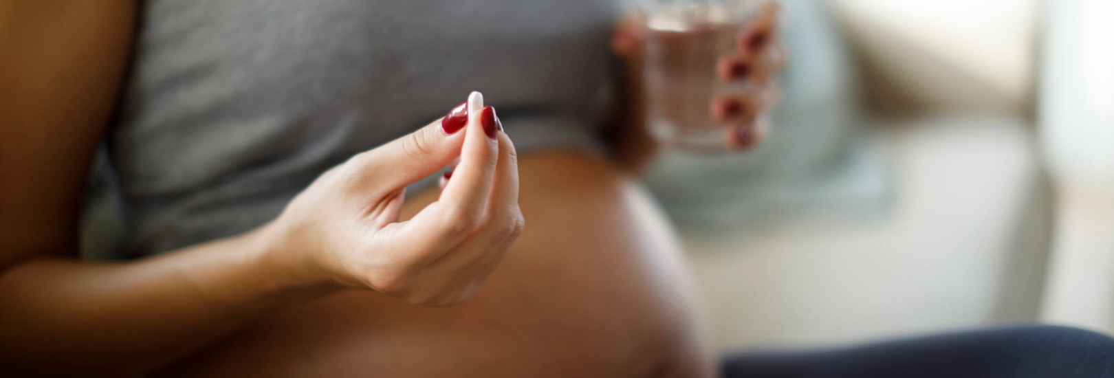 Schwangere Frau nimmt Tablette