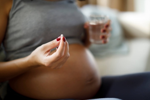 Schwangere Frau nimmt Tablette