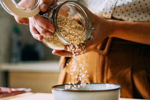Frau füllt Haferflocken eine Schüssel