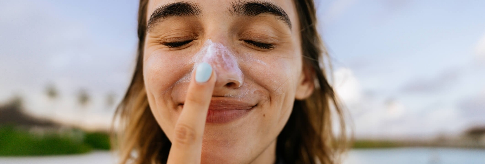 Junge Frau mit eingecremter Nase