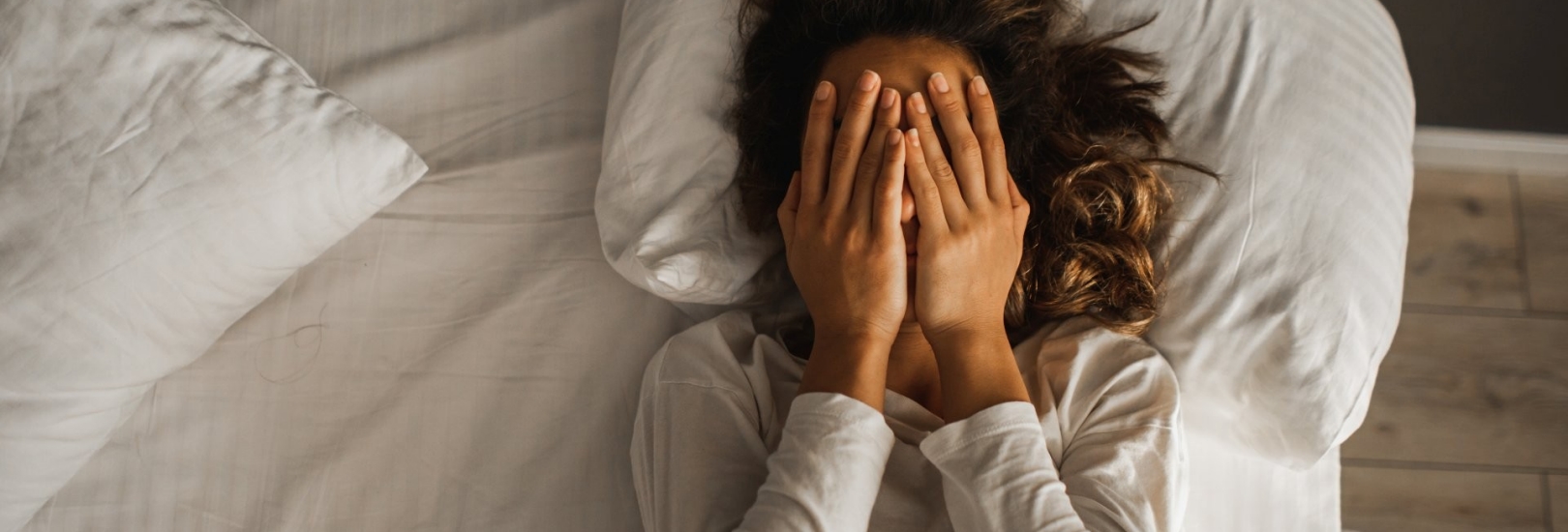 Frau liegt gestresst im Bett