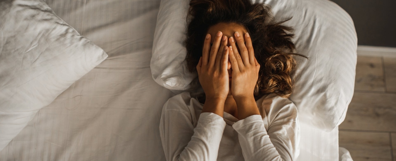 Frau liegt gestresst im Bett