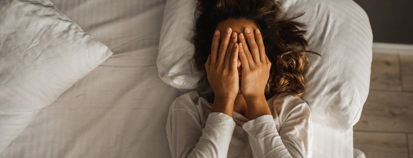 Frau liegt gestresst im Bett