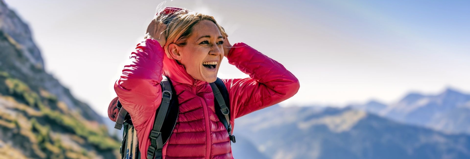 Glückliche Frau auf einer Wanderung in den Bergen genießt die Aussicht