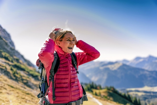 Glückliche Frau auf einer Wanderung in den Bergen genießt die Aussicht