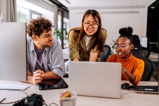 Drei junge Kollegen diskutieren über die Arbeit im modernen Büro