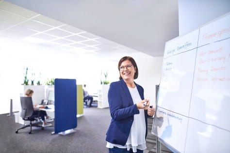 Frau schreibt an ein Whiteboard