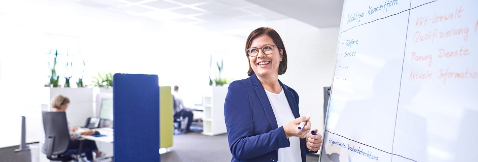 Frau schreibt an ein Whiteboard