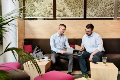 Zwei Vertriebsmitarbeitende in moderner Kaffee-Lounge