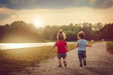 Zwei kleine Kinder toben im Freien.