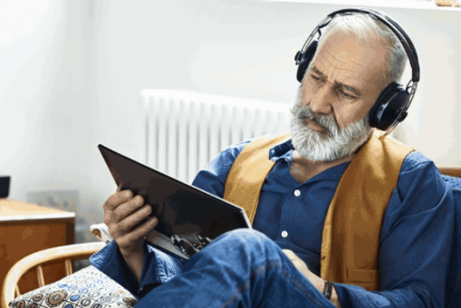Ein älterer Mann hört einen Podcast.