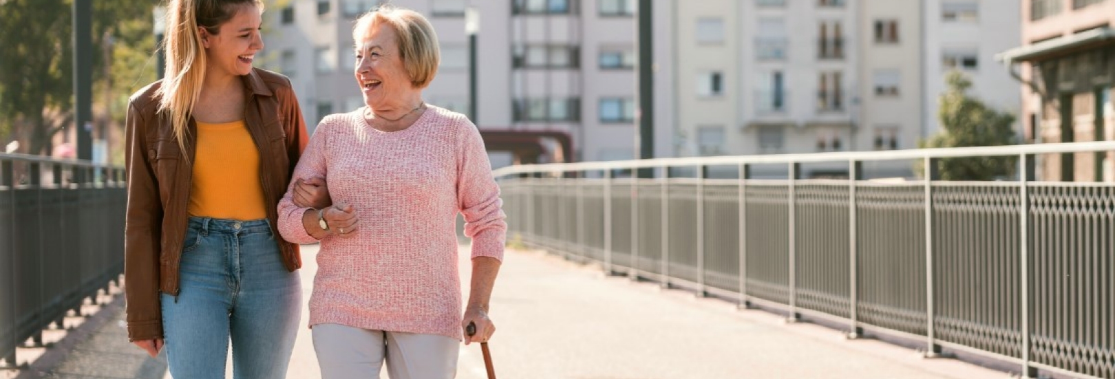 Eine junge Frau spaziert mit ihrer Oma in der Stadt.