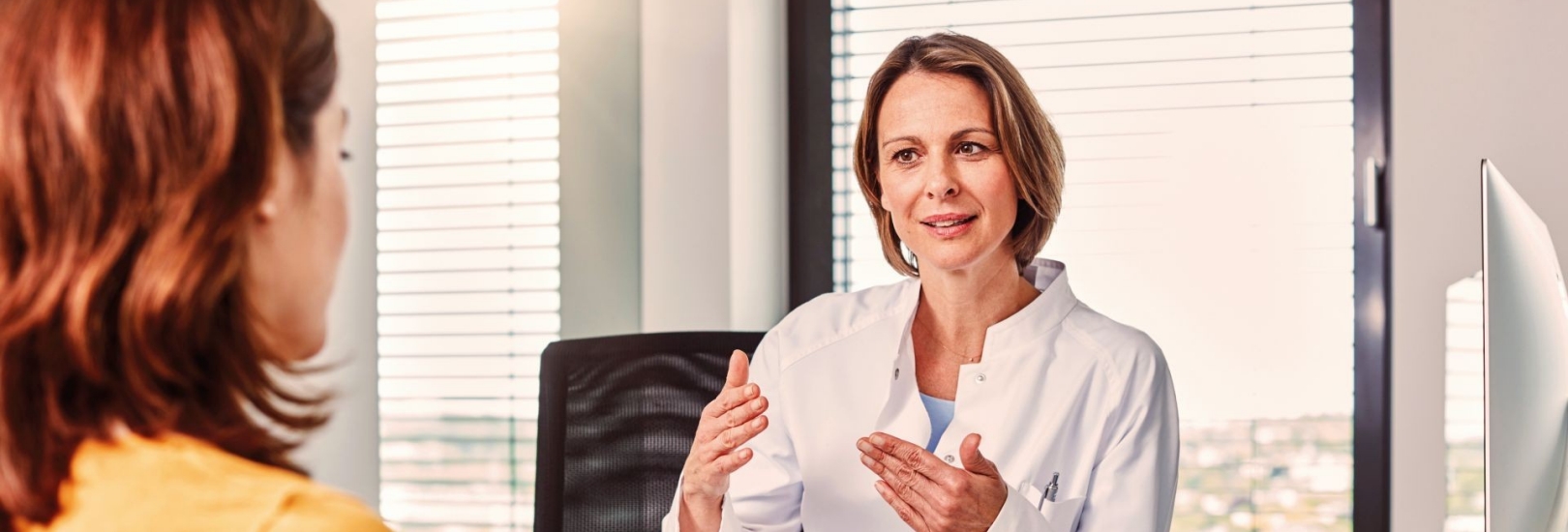 Eine Ärztin spricht mit einer Patientin in ihrem Arztzimmer.