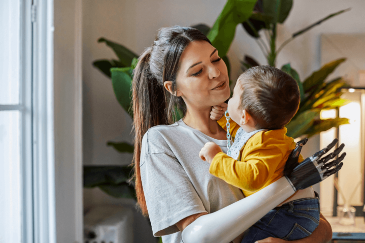 Eine junge Frau hält ein Baby im Arm.
